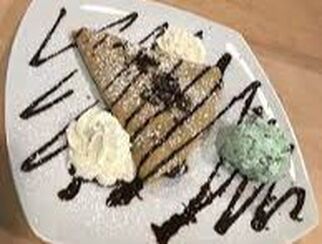 Plate of crepe garnished with ice cream, whipped cream and chocolate sauce in Parkwood Gardens, Guelph, Ontario