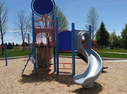 Small red and blue playground structure with a blue slide in Kortright Hills, Guelph, Ontario